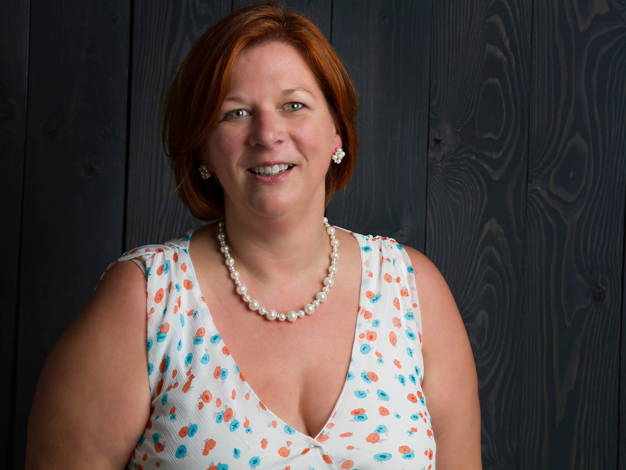 woman in her forties against a wood stained background