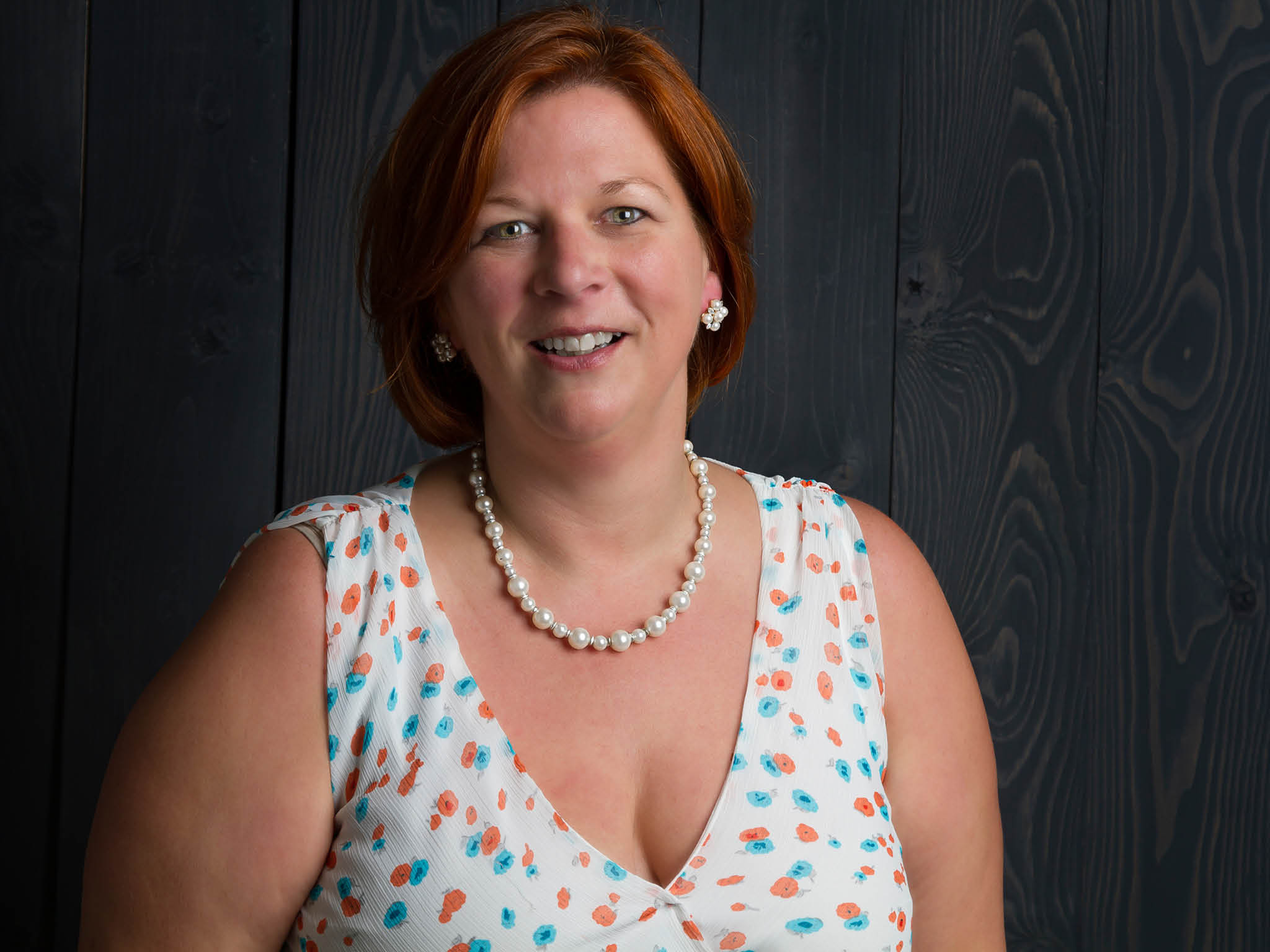 woman in her forties against a wood stained background