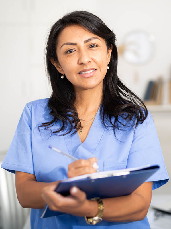 Nurse working on PC in modern private clinic with white walls