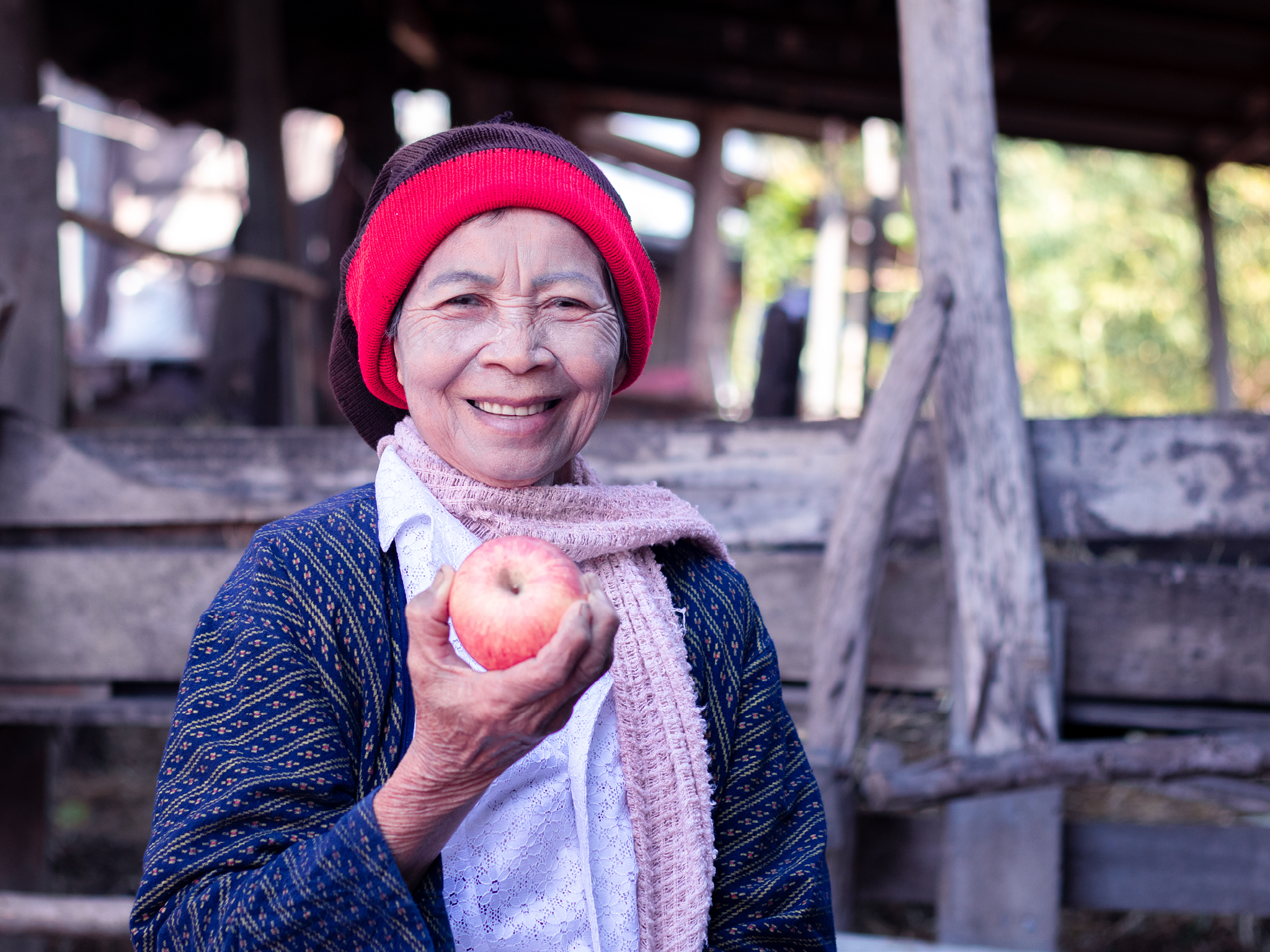 Asian senior woman holding and eating apple with smiling and happy.