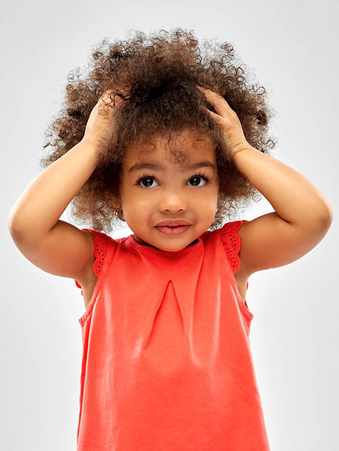 childhood and people concept - overwhelmed little african american girl holding to head over grey background