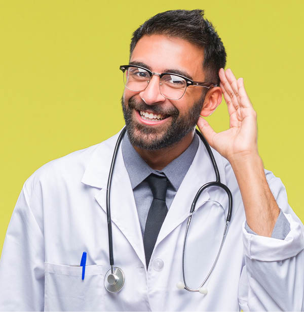 Adult hispanic doctor man over isolated background smiling with hand over ear listening an hearing to rumor or gossip. Deafness concept.