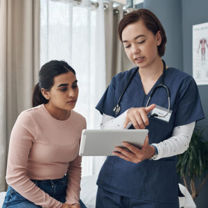 A medical student talks to a patient about the potential issues involved in a procedure.