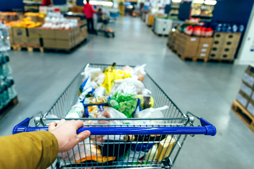 first person view. man with shopping cart in grocery store shopping concept