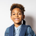 Portrait of a cute 6-year-old boy with dark skin and afro hair